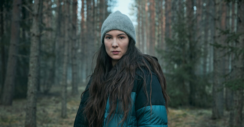 Lejla Ness standing in the forest in The Glass Dome on Netflix