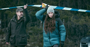 Valter and Lelja Ness lifting the police caution tape in The Glass Dome